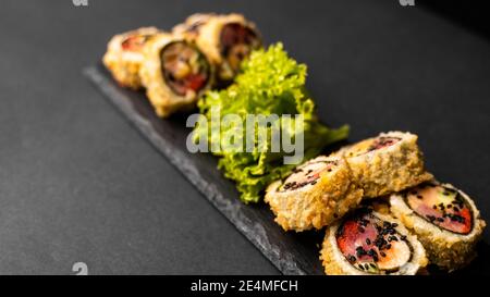 https://l450v.alamy.com/450v/2e4mfch/custom-sushi-roll-in-tempura-with-nori-fresh-salmon-tuna-avocado-masago-caviar-drizzled-with-pineapple-sauce-with-salad-pouring-as-decoration-on-2e4mfch.jpg