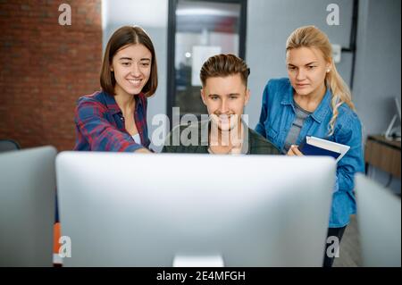 Smiling IT specialists works on computers, office Stock Photo