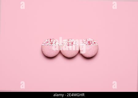 Three Valentines Day macarons with white icing and sprinkles.  Three pink macarons with copy space and room for text Stock Photo
