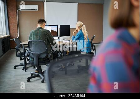 IT specialists works on computers, back view Stock Photo
