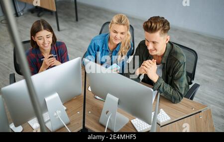 Smiling IT specialists works on computers, office Stock Photo