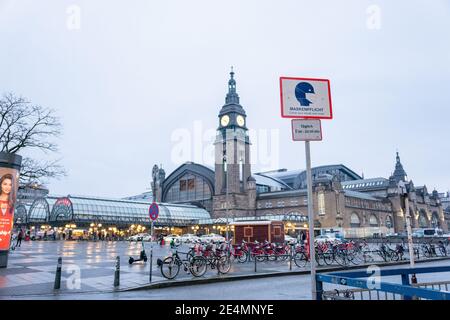 Hamburg, Germany - January: A sign in front of the main train station remembers that there is a mask requirement because of corona and covid-19. Stock Photo