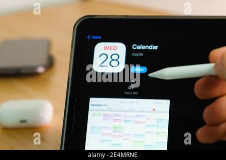 Apple Calendar logo shown by apple pencil on the iPad Pro tablet screen. Man using application on the tablet. December 2020, San Francisco, USA. Stock Photo