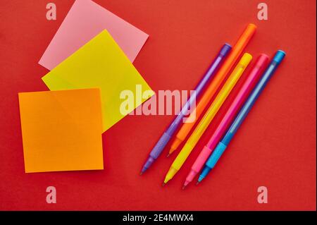 Pens and notepads closeup, red background Stock Photo