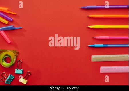 Pens, rulers and paper clips, red background Stock Photo
