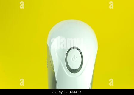 Close-up pushbutton switch on an electrical appliance. Konopka include with space for text on yellow background. On-off Stock Photo