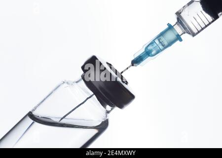 A syringe draws a vaccine from a medical bottle. On white Stock Photo