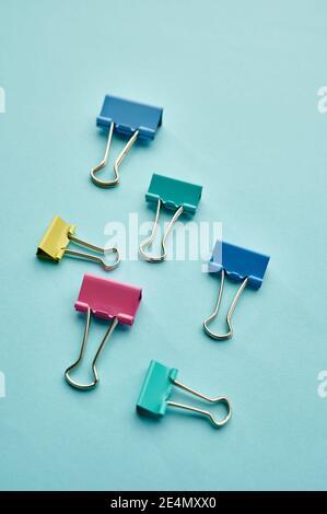 Colorful clips on blue background, stationery Stock Photo