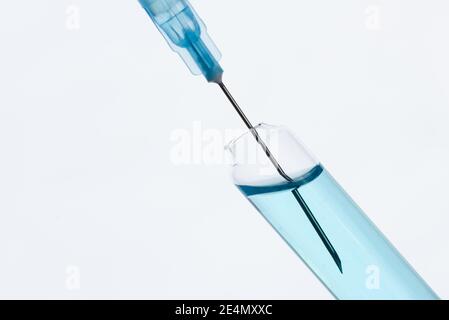 A syringe draws a vaccine from a medical bottle. On white Stock Photo
