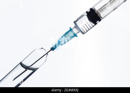 A syringe draws a vaccine from a medical bottle. On white Stock Photo