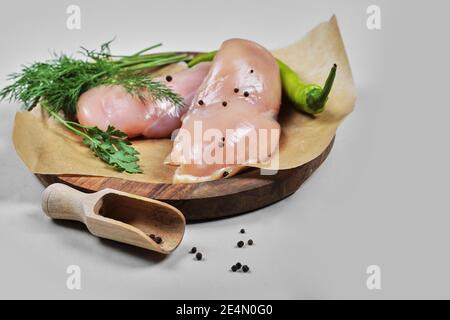 Raw chicken fillets on wooden plate with spoon Stock Photo