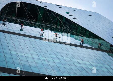 Group of industrial climbers washing glass office building facade, Moscow, 28.07.2020 Stock Photo