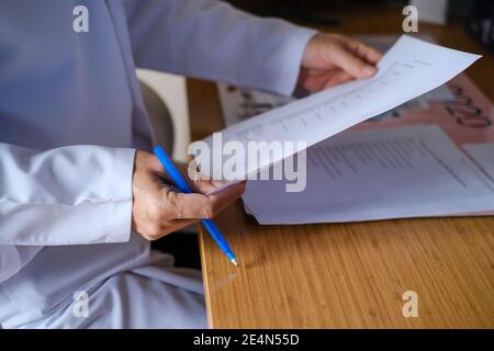 The doctor examines the patient's documents. Side  view of doctor hand writing prescription on paper. Health and medical concept. Stock Photo