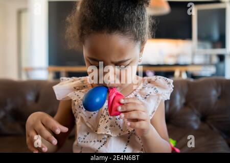 Little girl playing with balloons at home. Stock Photo