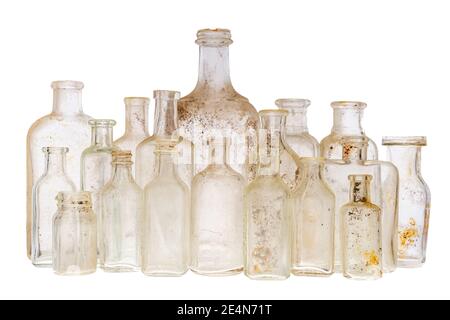 A collection of old antique bottles against a white background. There are 18 ancient bottles, and they are dirty. Focus on the front row. Stock Photo