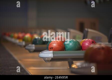 Graphic background image of ball return machines and bowling ball in row at entertainment center, copy space Stock Photo