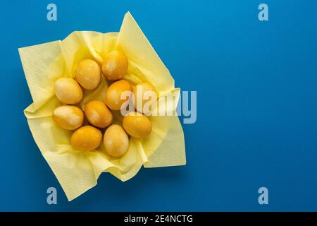 Easter yellow painted eggs in plate on bright blue background, easter festive concept Stock Photo