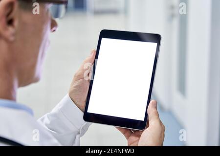 Male doctor holding digital tablet using blank white mockup screen technology. Stock Photo