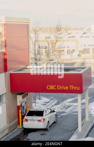 January 16 2021 - Calgary , Alberta Canada - Customer withdrawing cash from drive thru atm machine Stock Photo