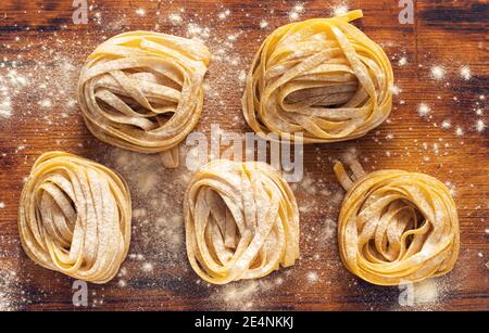 Fresh homemade pasta with flour and eggs on a wooden board. Useful environmentally friendly product. Stock Photo