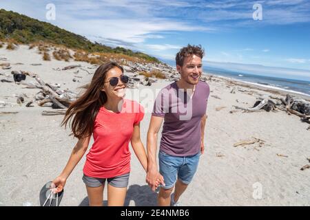 Couple walking on beach in New Zealand - people in Ship Creek on West Coast of New Zealand. Tourist couple sightseeing tramping on South Island of New Stock Photo