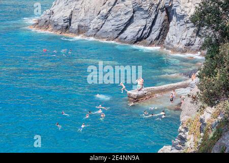 Holiday makers swimming, Manarola, Cinque Terre, Liguria, Italy Stock Photo