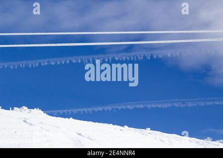 Two parallel ropes covered by icy snow on a background of blue sky with clouds making line forms. background blue and white. copy space. Stock Photo
