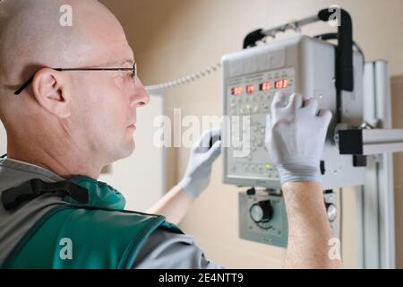 Serious mature doctor using x-ray equipment during his work at hospital Stock Photo