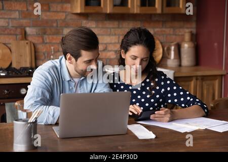 Young couple calculate expenses paying bills on laptop Stock Photo