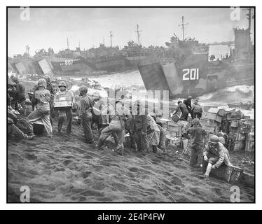 WW2 Iwo Jima supply beachhead World War II: Iwo Jima U.S. Coast Guard and US Navy vessels landing supplies on the Marine beachhead at Iwo Jima, Japan The sea mist giving a cinematic quality to a very real landing February 1945. Second World War Stock Photo