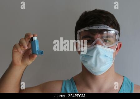 Propionate Rescue Inhaler man in full ppe shows how to use a rescue inhaler Stock Photo - Alamy
