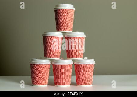 Pyramid of coffee cups with gray background. Cup of coffee. Takeaway or takeout business Stock Photo