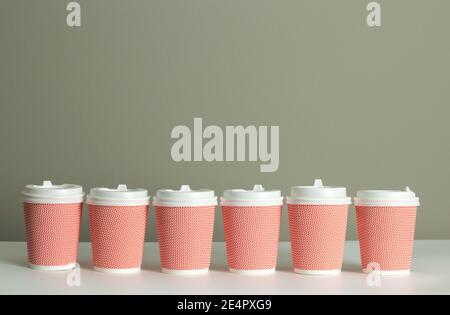 Row or line of coffee cups on desk with copy space background. Coffee commercial template design. Mock up for coffee takeout or takeaway business Stock Photo