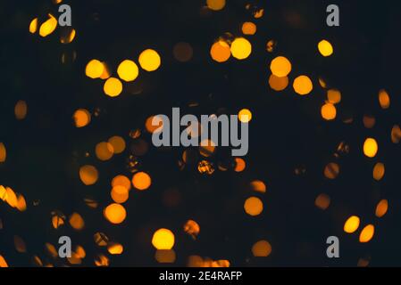 Defocused golden circle light bokeh on the black background. Stock Photo