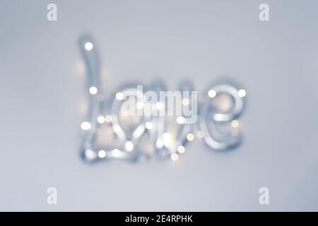 Blurred word Love with bokeh lights. Gray, silver background for Valentine day card. Love concept. Stock Photo