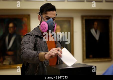 Lisbon, Portugal. 24th Jan, 2021. A man wearing a protective mask casts his ballot at a polling station during the Portuguese Presidential Election in Lisbon. Portugal is voting despite the country's pandemic lockdown in a presidential election widely expected to see incumbent Marcelo Rebelo de Sousa win another term. Credit: Pedro Fiuza/ZUMA Wire/Alamy Live News Stock Photo