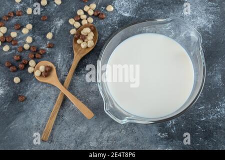 Bowl of milk and cereal balls on marble background Stock Photo