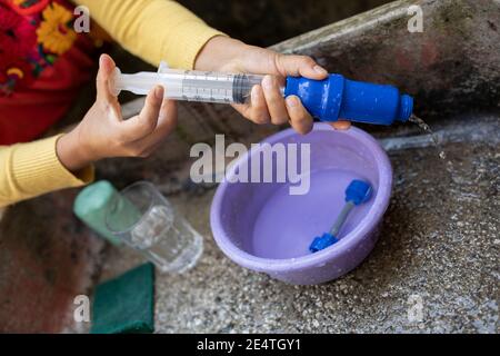 Backwash cleaning a home tap-based water filter system in use in San Juan la Laguna, Guatemala. Stock Photo