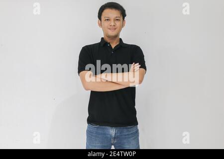 Portrait of smiling young asian man wearing black shirt and denim pant isolated on white. Stock Photo