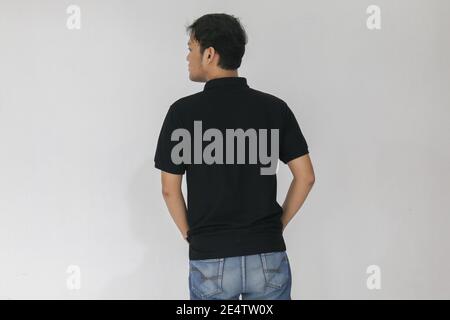 Portrait of smiling young asian man wearing black shirt and denim pant isolated on white. Stock Photo