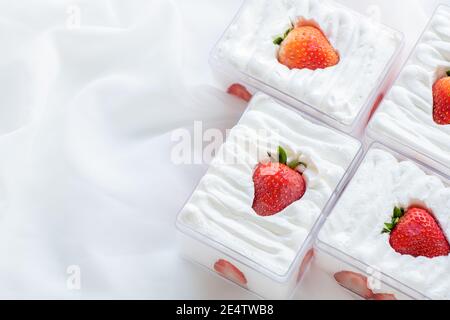 strawberry shortcake in plastic box on with cloth background and copy space, Minimal cake and bakery concept Stock Photo