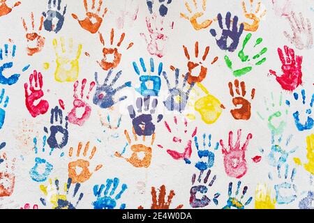 White wall with colorful multicolored hand prints. Stock Photo