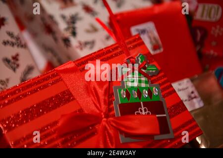 Christmas presents with gift tags - Christmas pile - wrapped gifts - present with gift tag under a Christmas tree - Christmas decorations and bows Stock Photo