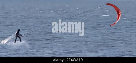 A person kitesurfing on the water on a windy day. Stock Vector