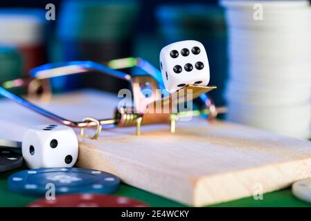 black dice and mousetrap, game trap, against the background of casino chips. Stock Photo