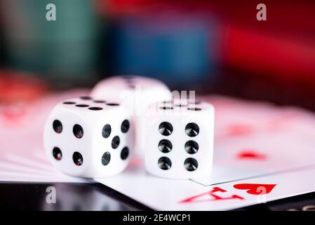 Black game dice and cards on the background of casino chips. Stock Photo