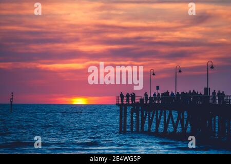 People strolling along the Glenelg Jetty at sunset, South Australia Stock Photo