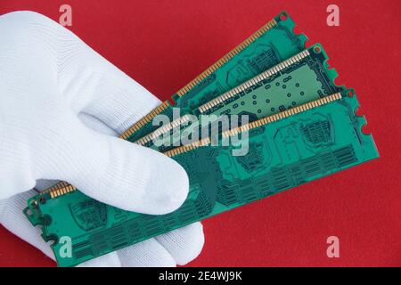 Hand in white glove holds a three computer memory card. Closeup. Stock Photo