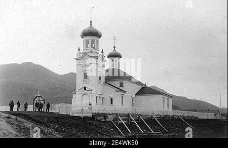 Men standing in front of Russian Orthodox church, Unalaska, ca 1899 (WARNER 430). Stock Photo