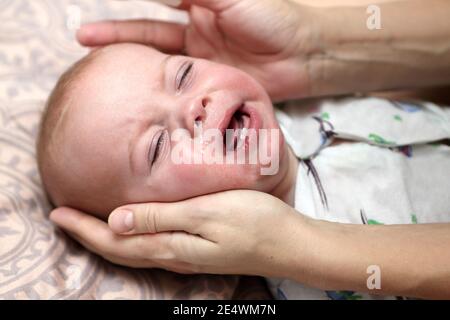 Ñrying child with a runny nose at home Stock Photo